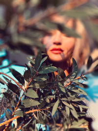 Close-up portrait of young woman with leaves