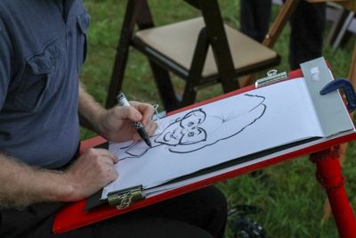 Midsection of man drawing on paper