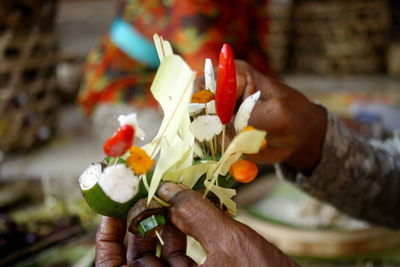 Close-up of hand holding bouquet of red roses