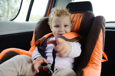 Portrait of cute baby girl sitting in car