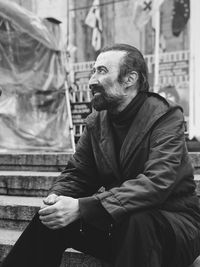 Man sitting on staircase in city