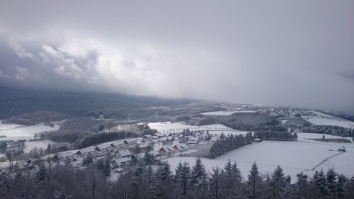 Scenic view of townscape against cloudy sky