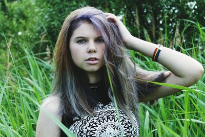 Portrait of young woman with brown hair by grass