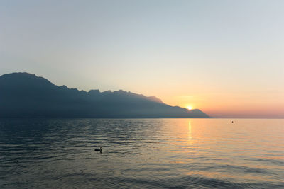 Scenic view of lake against clear sky during sunset