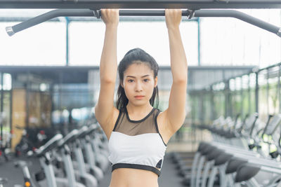Portrait of young woman exercising at gym