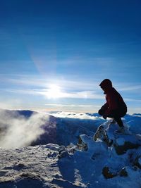 Man on snowcapped mountain against sky