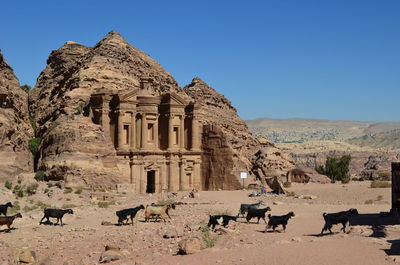 Group of people in front of built structure against clear blue sky