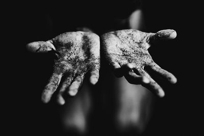 Close-up of human hand against black background