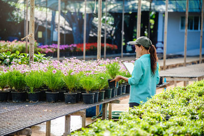 Woman standing by flowering plants