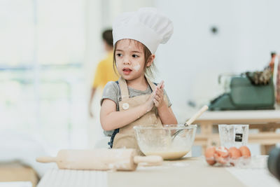 Cute baby girl in bowl on table