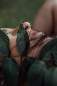 Close-up of leaves on face of woman