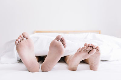 Low section of woman sleeping on bed