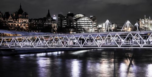 View of bridge over river at night