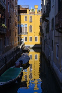 Boats in canal amidst buildings in city