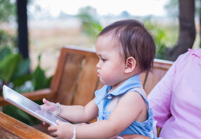 Cute boy looking while sitting outdoors