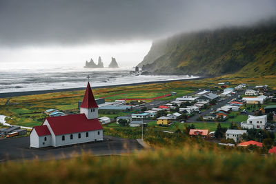 Buildings by sea against sky