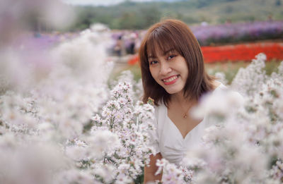 Portrait of young woman standing against sky