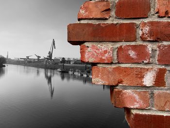 Red wall by river against sky