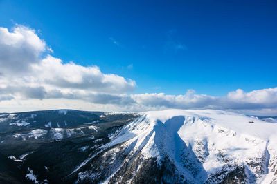 Panoramic view of snowcapped mountains against blue sky