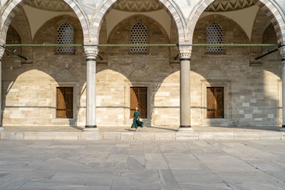 Man walking in front of historical building