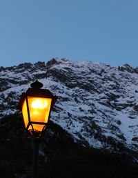 Low angle view of illuminated street light against clear sky