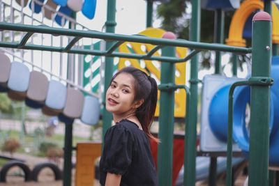 Portrait of smiling young woman standing in playground