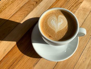 A cup of coffee latte on a wooden table. a mug of flat white coffee on a wooden background. coffee