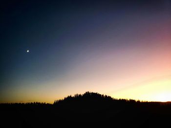 Silhouette landscape against clear sky during sunset