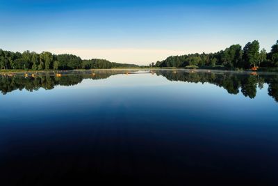 Scenic view of lake against clear blue sky