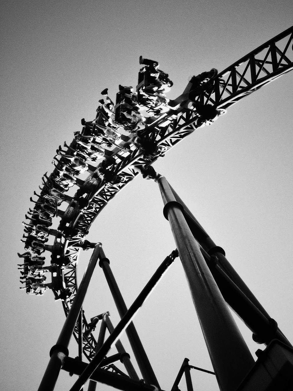 low angle view, clear sky, built structure, architecture, metal, sky, metallic, copy space, no people, silhouette, amusement park ride, amusement park, outdoors, day, lighting equipment, arts culture and entertainment, tall - high, religion, tower, high section