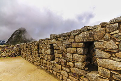 View of stone wall against cloudy sky
