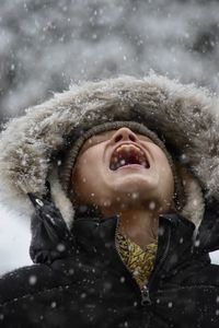 Close-up of boy looking up in snow