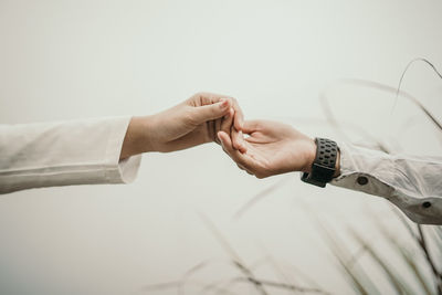 Midsection of couple holding hands