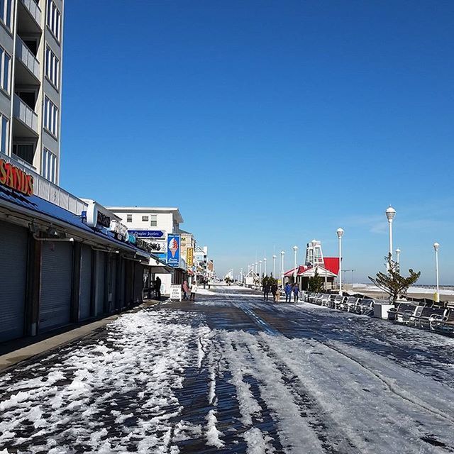 clear sky, the way forward, blue, building exterior, built structure, architecture, copy space, transportation, street, diminishing perspective, road, street light, empty, vanishing point, incidental people, day, long, sunlight, car, outdoors