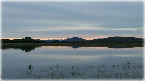 Scenic view of lake against cloudy sky