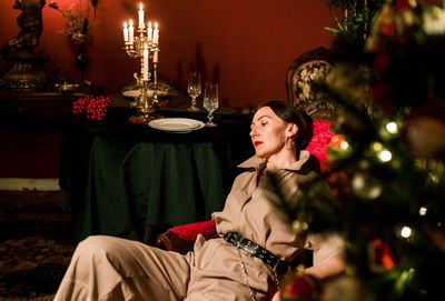 Chic woman poses in a vintage living room interior with decorations and furniture.