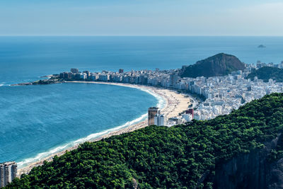 High angle view of townscape by sea against sky