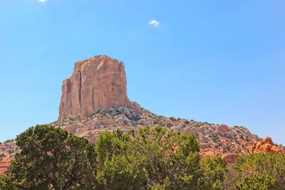 Rock formations on mountain against blue sky