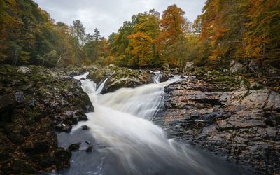 Scenic view of waterfall against sky