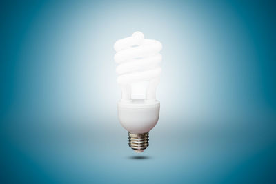 Close-up of light bulb against blue background