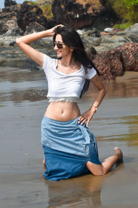 Portrait of young woman standing at beach