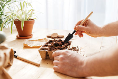 Cropped hand of person preparing food on table