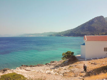 Scenic view of sea and mountains against clear sky