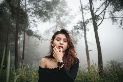 Portrait of a beautiful young woman standing on land