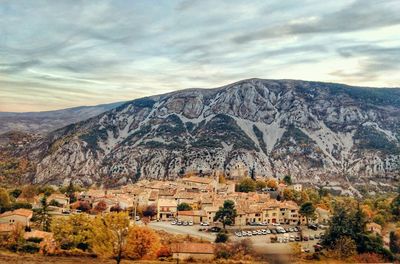 Houses on mountain against cloudy sky