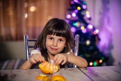 Portrait of girl holding ice cream on table