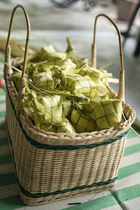 A basket fill with ketupat,  traditional malay cuisine made with coconut leaves for eid celebration.