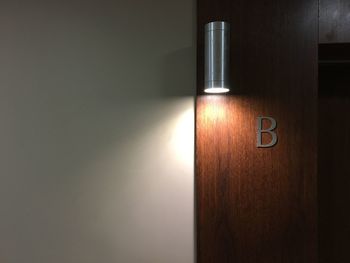 Close-up of illuminated lamp mounted on wall