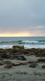 Scenic view of beach against sky during sunset