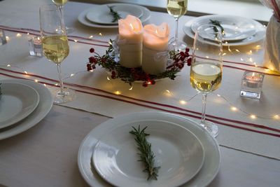 High angle view of wineglasses with christmas lights on table